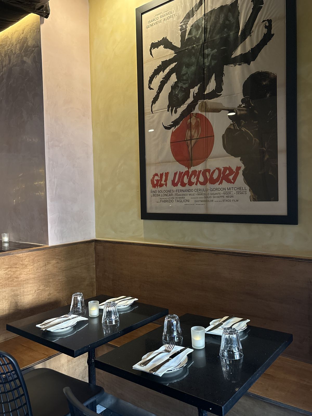 Dining room tables beneath a vintage Italian film poster