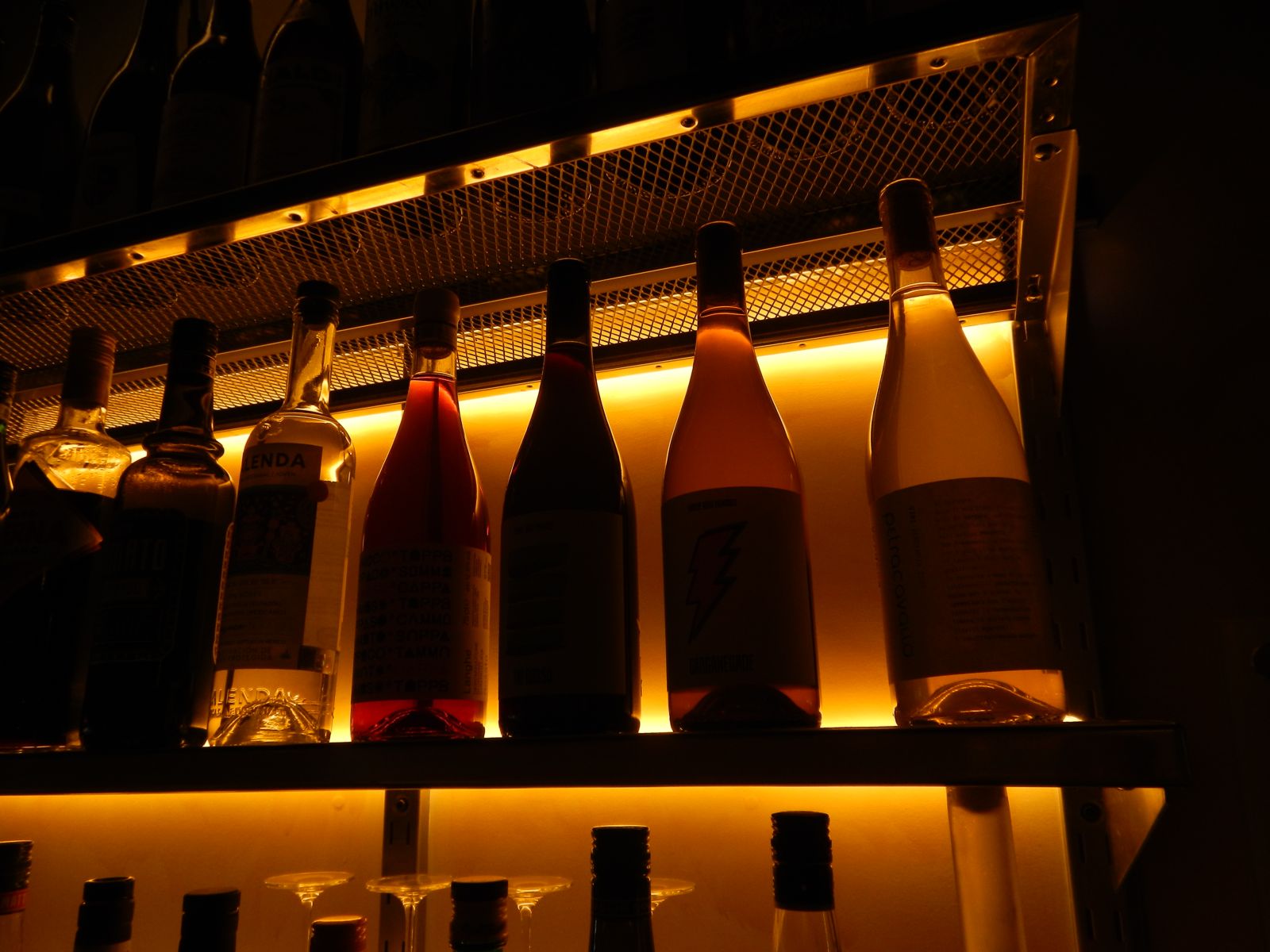 Wine bottles glowing on a backlit shelf