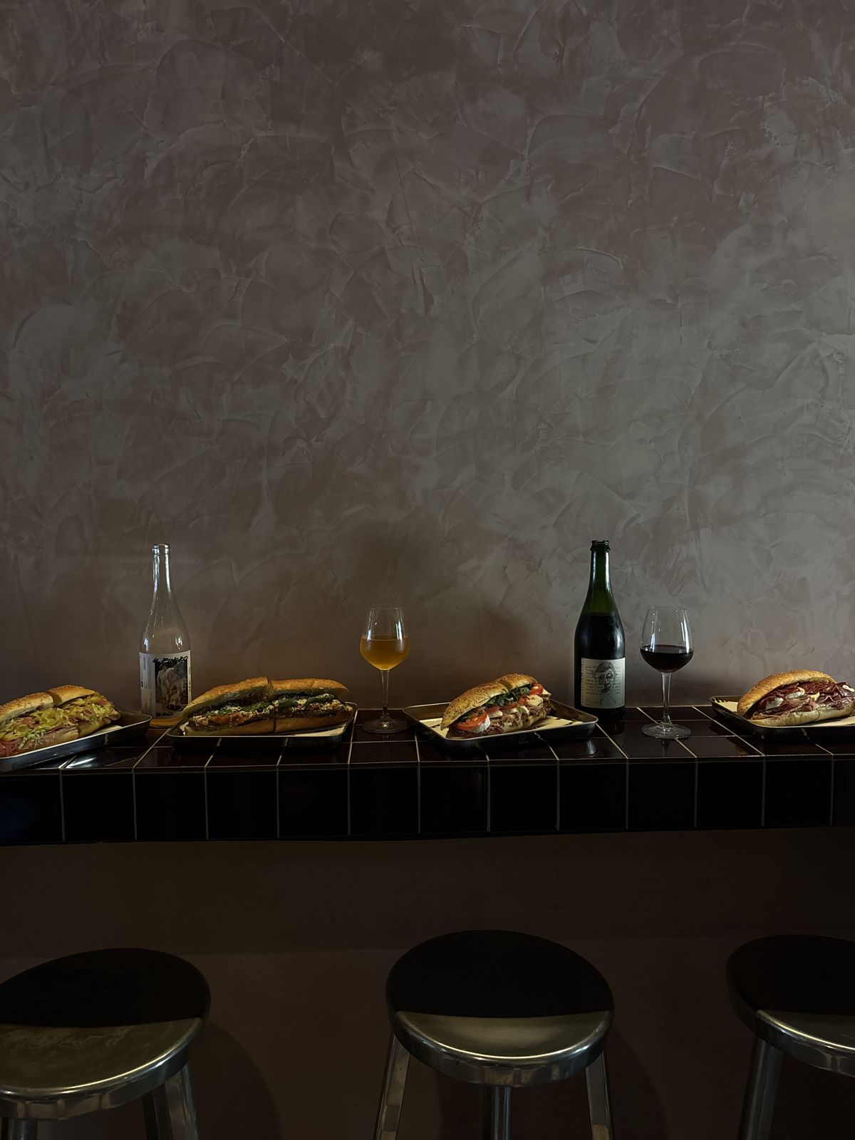 Sandwiches and natural wine on the tiled bar counter